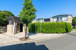 a tree in front of a house with a building at WeBase KAMAKURA in Kamakura