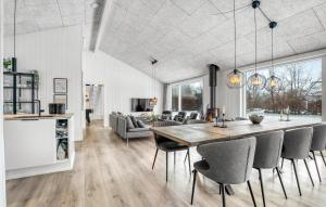 a kitchen and living room with a table and chairs at Amazing Home In Væggerløse With Sauna in Marielyst