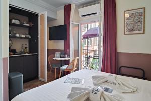 a room with a bed and a kitchen and a table at Aparthotel AMMI Vieux Nice in Nice
