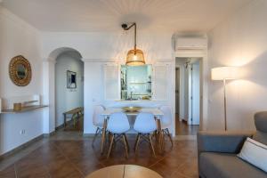 ein Wohnzimmer mit Tisch und Stühlen und einer Couch in der Unterkunft Marina III by Ĥ - Marina Isla Canela PMHIII37P5 in Punta del moral