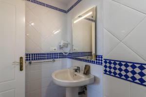 ein Badezimmer mit Waschbecken und Spiegel in der Unterkunft Marina III by Ĥ - Marina Isla Canela PMHIII37P5 in Punta del moral + 15 Fotos