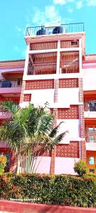 a tall building with palm trees in front of it at Amazing Grace Homes ( AG Homes) in Oyugis