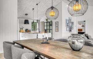 a dining room with a table with a vase on it at Amazing Home In Væggerløse With Sauna in Marielyst