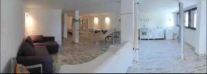 a living room with a couch and a kitchen at Nido dell'Argentario - Porto Santo Stefano in Porto Santo Stefano