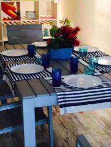 a table with plates and blue glasses on it at Nido dell'Argentario - Porto Santo Stefano in Porto Santo Stefano +8 photos