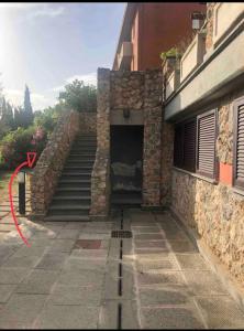 a building with a garage with a stairway in front at Nido dell'Argentario - Porto Santo Stefano in Porto Santo Stefano