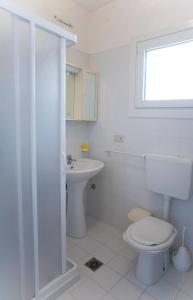 a white bathroom with a toilet and a sink at Apartment in San Michele al Tagliamento 45669 in San Michele al Tagliamento
