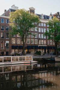 a boat on a river in front of a building at Hotel Estheréa in Amsterdam