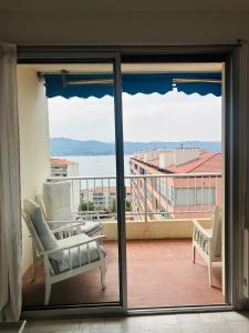 a view of a balcony with a chair and a window at T2 vue mer à 8 min du centre ville d'Ajaccio et 1 min des plages in Ajaccio