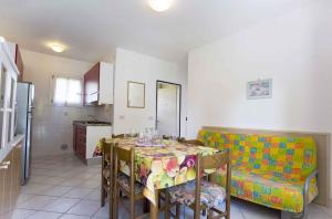 a kitchen with a table and a couch in a room at Apartment in San Michele al Tagliamento 45669 in San Michele al Tagliamento +2 photos