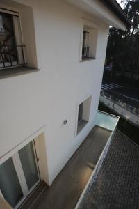 een balkon met uitzicht op een wit gebouw bij H5-5H Luxury Room in Maranello