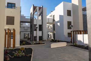 a courtyard of a building with white buildings at Casa Paraiso in Caleta De Fuste