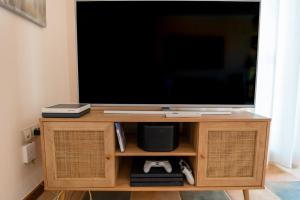 a tv on a wooden stand with a television at Villa V8 in Caleta De Fuste