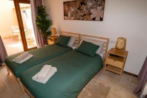 two beds in a bedroom with green sheets and towels at Villa V8 in Caleta De Fuste +40 photos