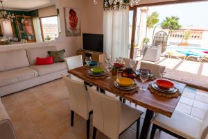 a dining room and living room with a table and chairs at Villa V8 in Caleta De Fuste