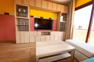 een woonkamer met een tv aan de muur bij Casa Carola - Bahia Sol in Caleta De Fuste +10 foto's