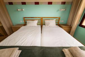 een slaapkamer met twee bedden met witte lakens bij Casa Carola - Bahia Sol in Caleta De Fuste