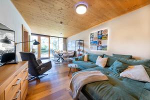 a living room with a green couch and a table at Residenz Wildkogelbahnen Top 20 in Neukirchen am Großvenediger