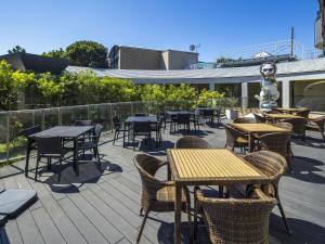 an outdoor patio with tables and chairs and tablesearcher at WeBase KAMAKURA in Kamakura