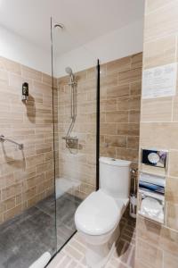 een badkamer met toilet en glazen douche bij Atlas Hotel in Valkenburg