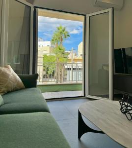 a living room with a couch and a large window at Centro 247 Luxury apartment in Ierápetra