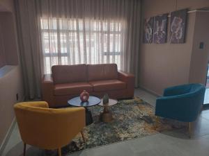 a living room with a couch and two chairs at The Hill Boutique Hotel in Tsolo +2 photos