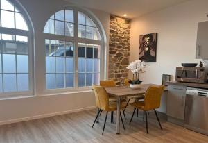 a kitchen and dining room with a table and chairs at Séjour au bord de la mer in Barneville-Carteret +8 photos
