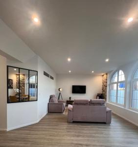 a living room with two couches and a flat screen tv at Séjour au bord de la mer in Barneville-Carteret