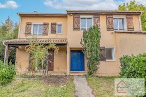 una casa con una porta blu e un cortile di Maison Évasion - Piscine, Jardin & Barbecue a Oullins