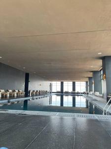 a large swimming pool with chairs in a building at KingSize Suite in Reforma Jacuzzi & Awesome Mexico City View in Mexico City