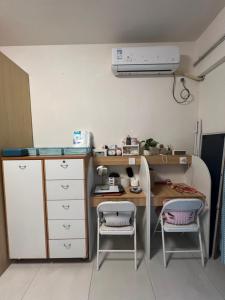 广州Feng3 Girls Hostel的小房间设有一张桌子和两把椅子 更多7张照片
