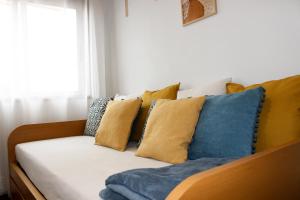 a couch with blue and yellow pillows on it at Apartament F&M in Braga