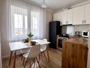 a kitchen with a white table and chairs in a room at Easy Apart in Taldykolʼ