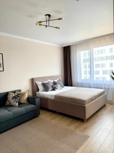 TaldykolʼにあるEasy Apartのベッドとソファのある寝室