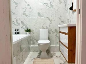 a bathroom with a toilet and a tub and a sink at Easy Apart in Taldykolʼ