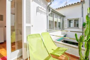 a balcony with a green chair and a cactus at Ca Se Predine by Rentallorca in Alcudia