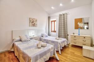 a bedroom with two beds and a dresser at Ca Se Predine by Rentallorca in Alcudia