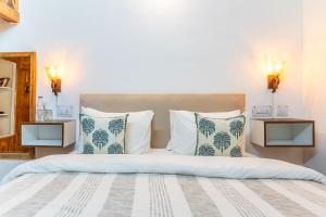 a bedroom with a large bed with blue and white pillows at House of Hive, Mukteshwar in Mukteswar