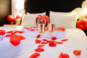twee glazen champagne op een bed met rozen bij Atlas Hotel in Valkenburg +37 foto's