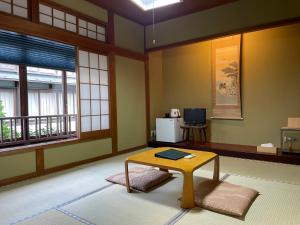 a room with a table in a room with windows at 湯宿ささくら in Kinosaki