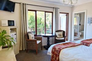 a hotel room with two beds and a balcony at Cherry Berry Guest House in George +60 photos