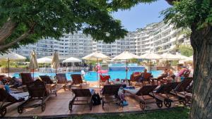 un gruppo di persone seduti su sedie vicino alla piscina di Emerald Beach Resort welnes & spa a Ravda