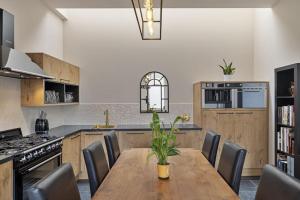 a kitchen with a wooden table and chairs and a kitchen with a stove at Guesthouse Gatsby in Ieper