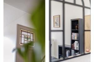 a living room with a book shelf and a window at Guesthouse Gatsby in Ypres