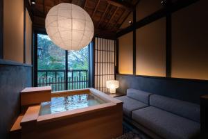 京都Nazuna Kyoto Higashi Honganji的客房设有热水浴缸和大窗户。