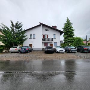un grupo de coches aparcados delante de una casa en Pokoje u Julii 2 Bedroom Premium Apartment, en Rzeszów