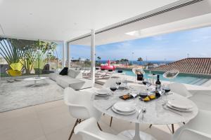 a white dining room with a table and white chairs at Karat Villa Murano in Callao Salvaje