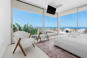a living room with white furniture and large windows at Karat Villa Murano in Callao Salvaje +27 photos