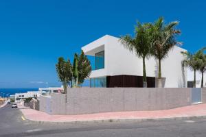 a white house with palm trees on a street at Karat Villa Murano in Callao Salvaje