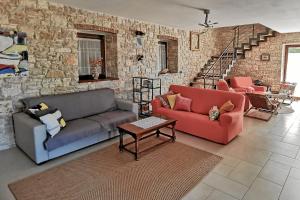 a living room with two couches and a brick wall at Casa Le Finide in Bale